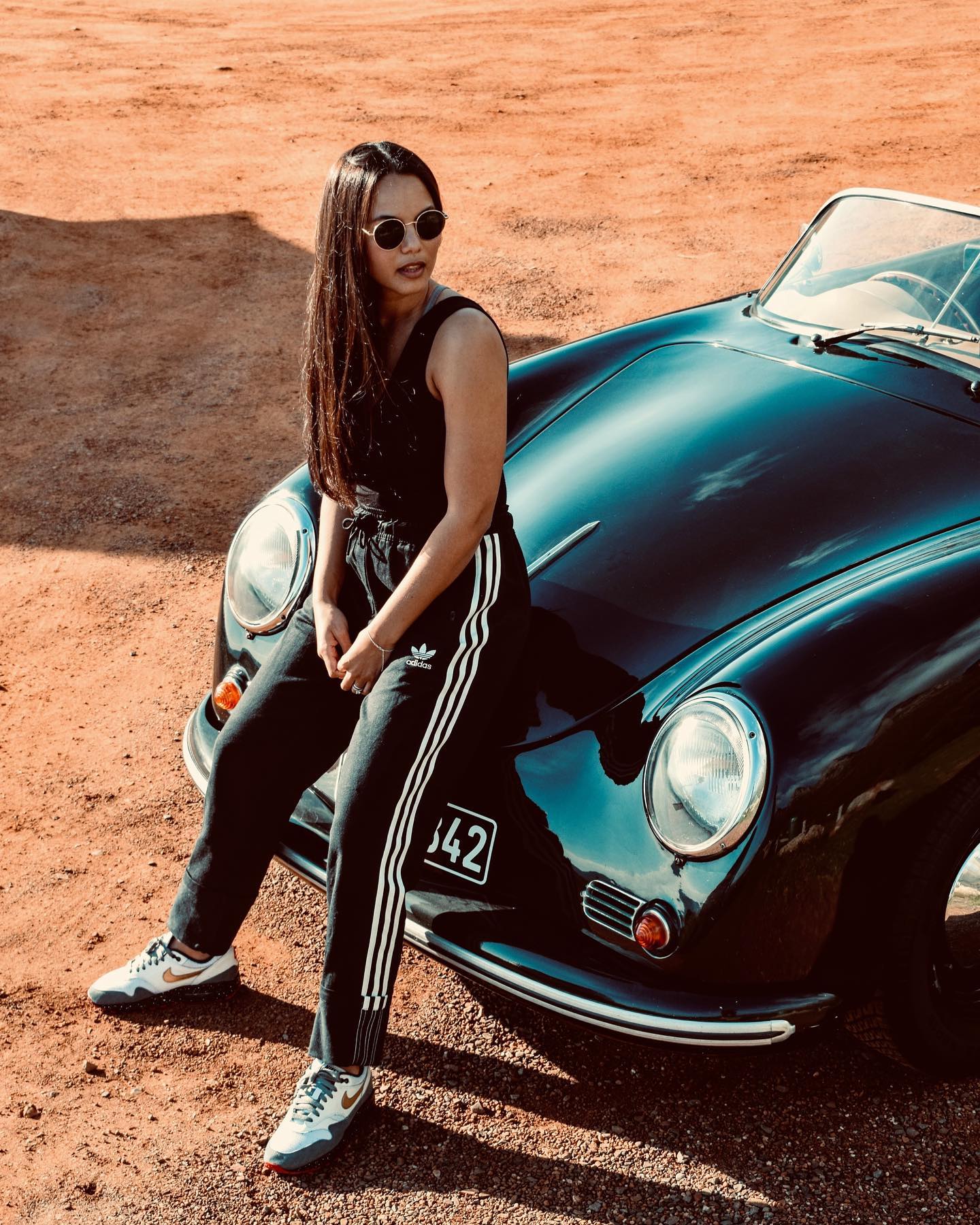 Fashion portrait of a woman beside the front of the black Speedster