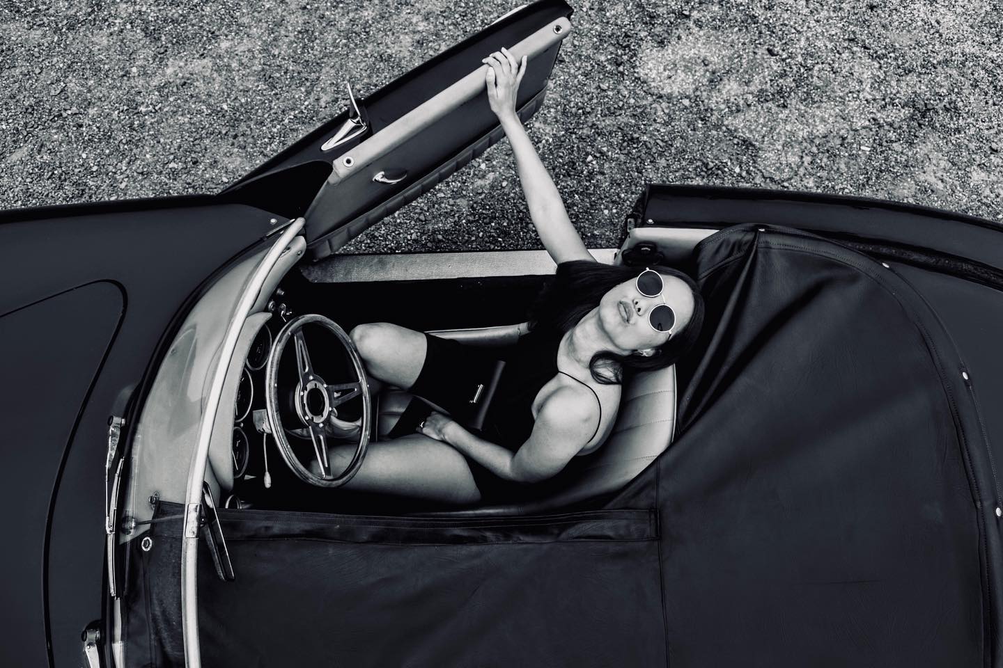 Black-and-white overhead portrait of a woman seated in the Speedster